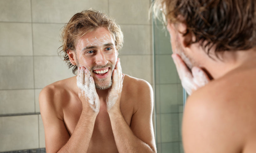 man in 20s exfoliating face