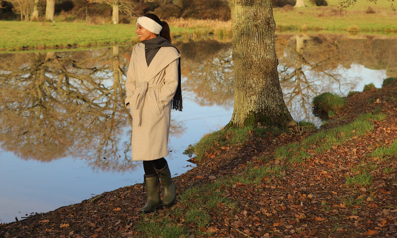 woman walking by a pond in autumn