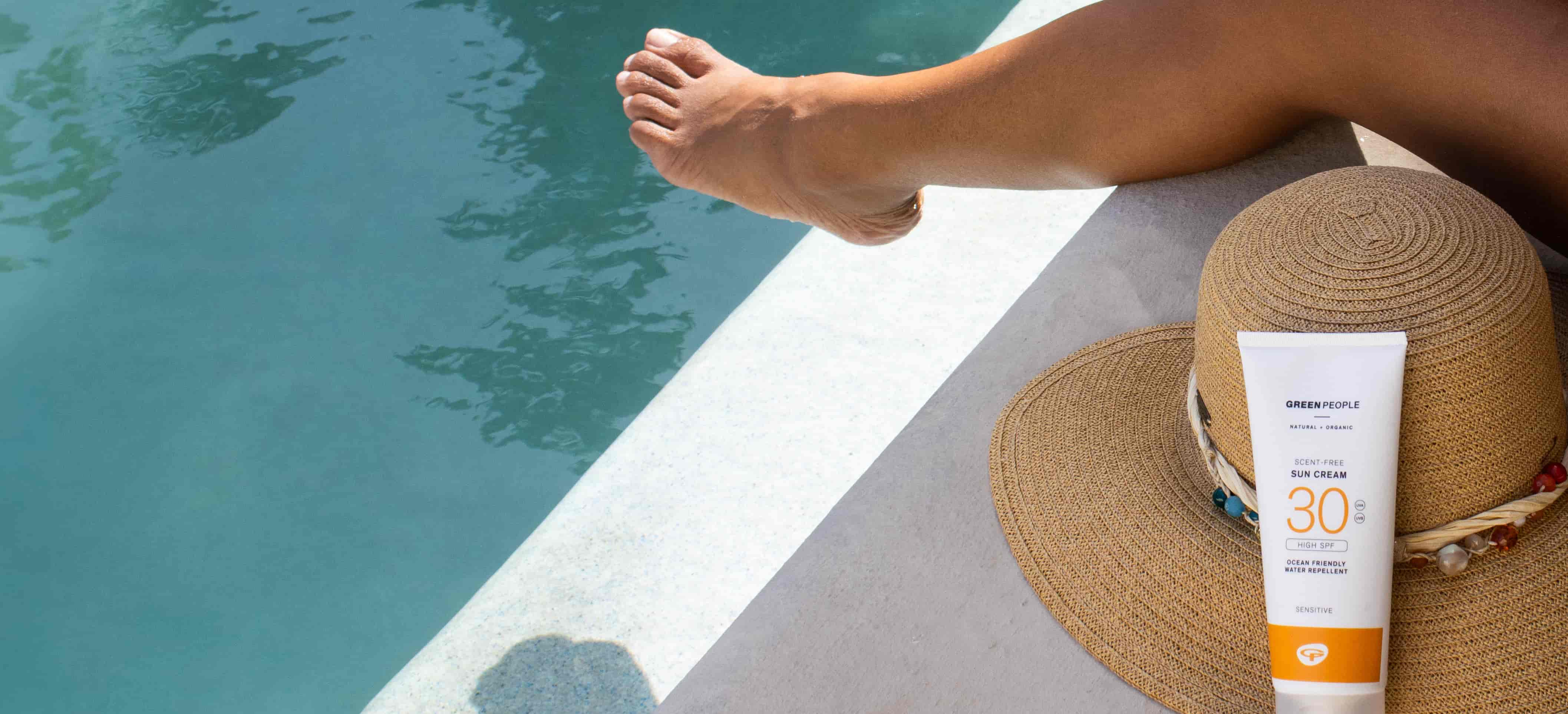 alcohol-free sunscreen and hat by pool