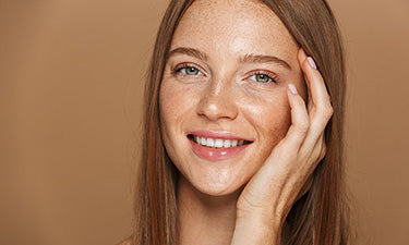 image for anti-ageing eye cream category featuring lady smiling and touching face