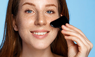 woman using gua sha beauty tool