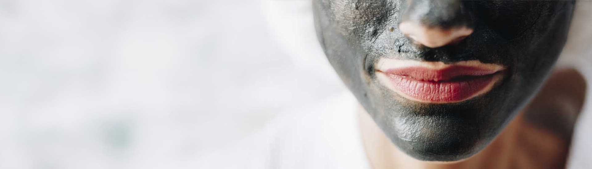 woman with natural charcoal face mask on face