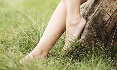 banner for organic foot cream category featuring feet in grass