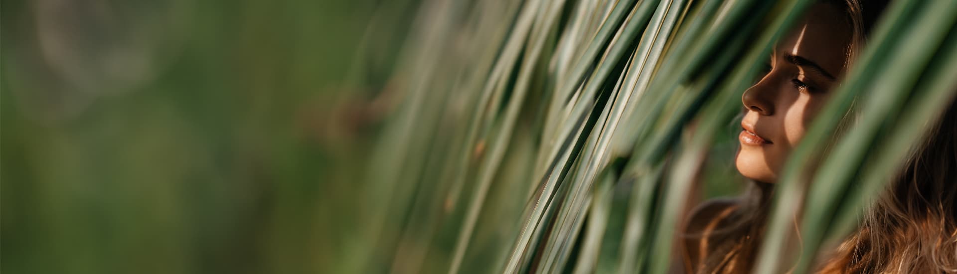 banner for vegan shampoo and conditioner featuring woman looking through leaves